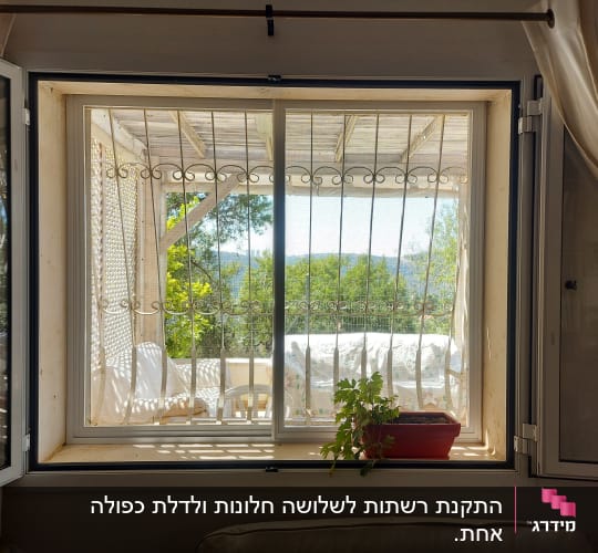 חלון אלומיניום עם סורגי מתכת נראים מבחוץ